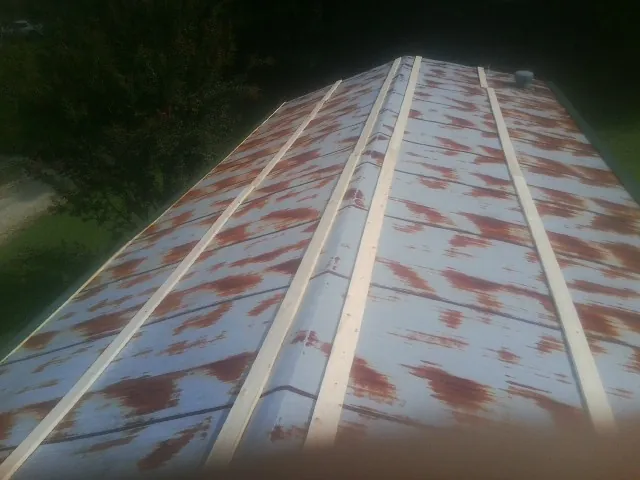 Rusted metal roof panels with new wood purlins before replacement — Storm Damage Roof Repair in Charlottesville by Roofing Brothers