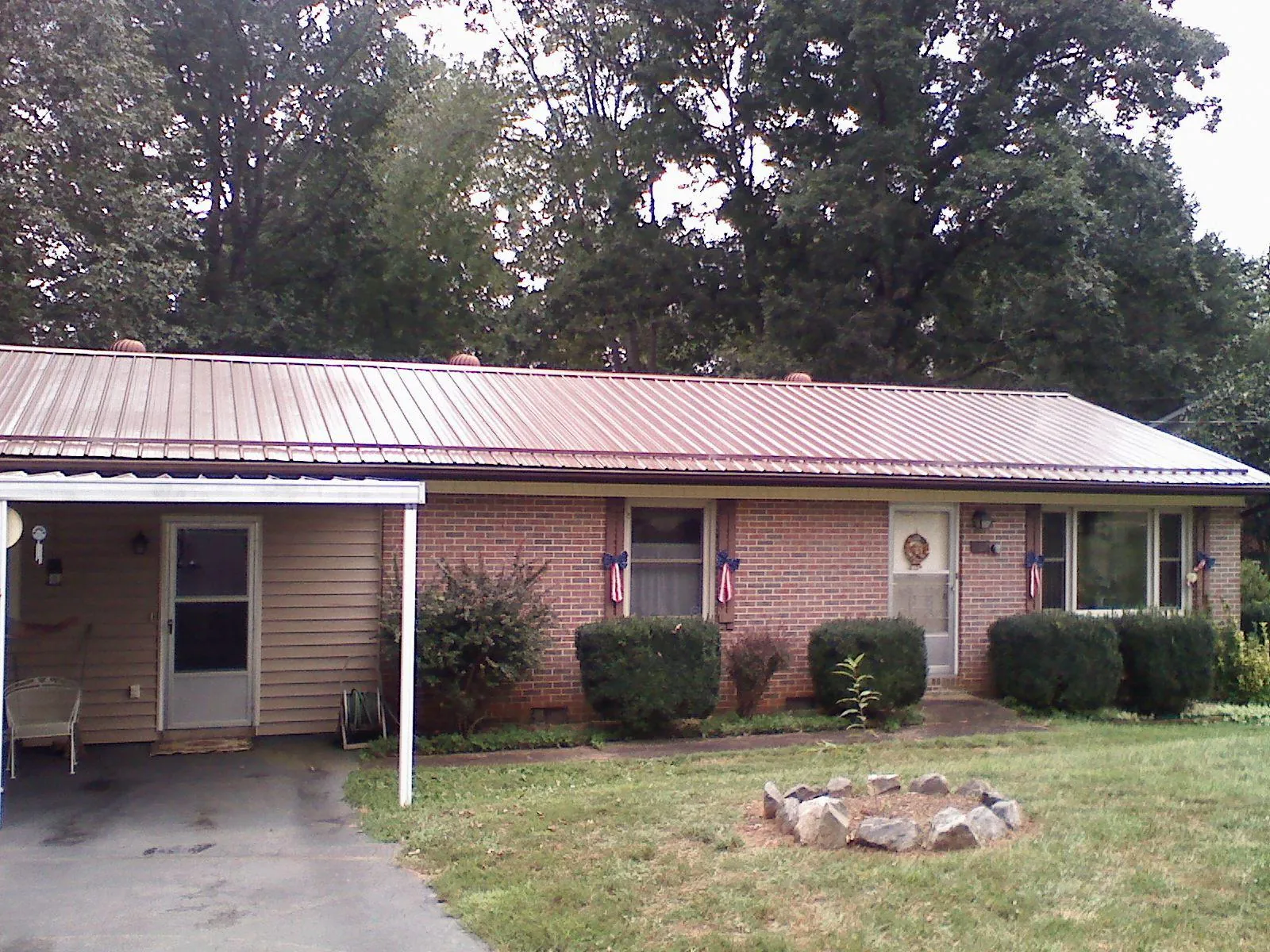 Bronze metal roof and carport on a brick ranch home — Roof Repair work by our crew in Charlottesville